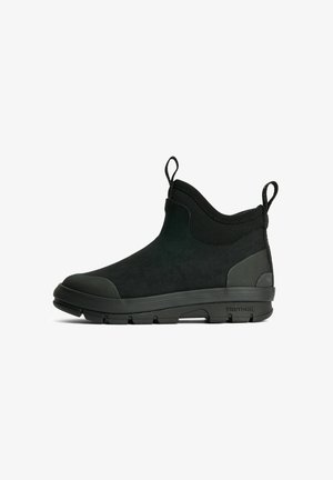 Sort ankelhøj slip-on sko med tyk gummisål, teksturerede tå- og hælkapsler samt stoftrækflige foran og bagpå.