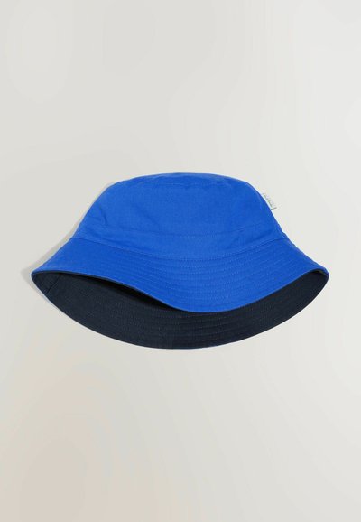 Bob réversible bleu et noir avec bordure cousue et petite étiquette blanche sur le côté, sur un fond uni.