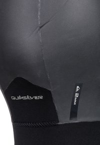 Quiksilver 2mm wetsuit segment in dark gray and black. Smooth texture with sewn seams, featuring brand logos. Rubberized panels enhance flexibility.