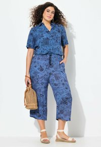 Blauwe gestreepte shirt met korte mouwen, bijpassende cropped broek, geweven tas en sandalen met banden. Heeft een relaxte pasvorm en een trekkoord in de taille.