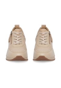 Beežid spordijalatsid sileda nahapinna, ümmarguse varbaga, paelad, külgkaset, ning tekstuuriga kummitald. Omab perforatsiooni detaile.