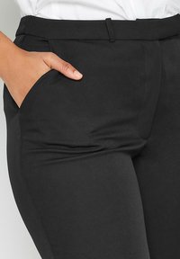 Svarta skräddarsydda byxor av en mjuk tyg, med sidofickor, platt framsidan och en smal passform.