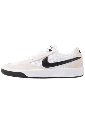 Białe i beżowe niskie buty sportowe Nike z czarnym logo Swoosh, białymi sznurówkami, siateczkowym materiałem i czarnym detalem podeszwy.