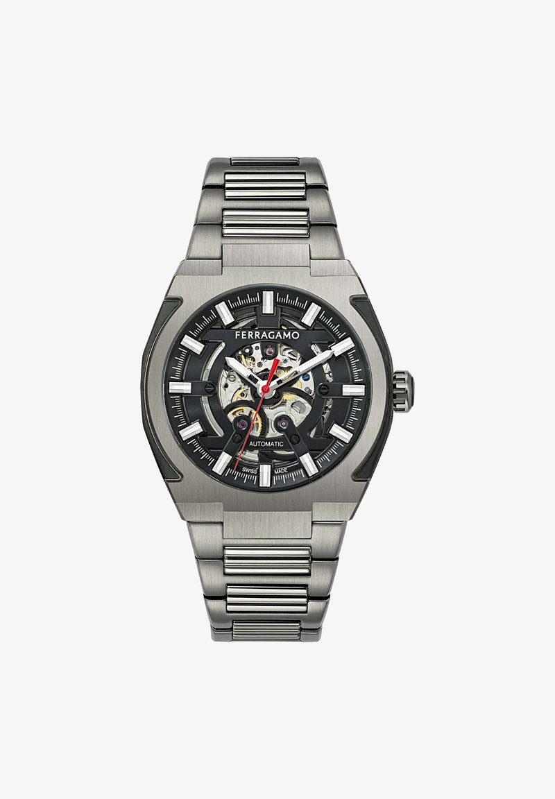 Ferragamo automaatne kell musta näo, hõbedaste tunnisilmade ja läbipaistva tagaküljega. Omab roostevabast terasest rihma ning nurkadena disainitud korpust.