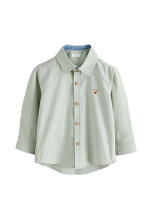 Hellgrünes Langarmshirt für Kleinkinder mit Holzknöpfen und kleinem braunem Bärengesicht auf der Brust bestickt.