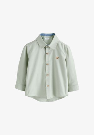 Hellgrünes Langarmshirt für Kleinkinder mit Holzknöpfen und kleinem braunem Bärengesicht auf der Brust bestickt.