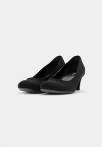 Zwarte high heels met een afgeronde neus, zacht materiaal, gladde textuur en een middenhoogte hak. Minimalistisch ontwerp zonder zichtbare hardware.