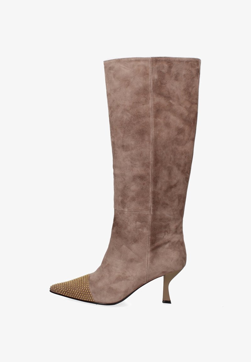 Stivale in suede fino al ginocchio color taupe con punta affilata, dotato di una punta decorata con borchie dorate e un tacco sottile. Texture liscia con dettagli minimi.
