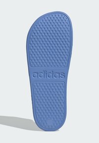 Plava gumena peta sa teksturiranom površinom, s uzdignutim točkicama za bolji grip i urezanim "adidas" logotipom sa strane.