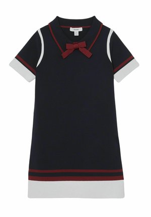 Mornarska haljina s crvenim i bijelim naglascima. Ima ovratnik, kratke rukave i crveni mašnu na izrezu. Glatka tekstura, jednostavan dizajn.