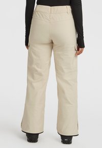 Beige skibroek met een gladde, waterafstotende stof, rechte pijpen, cargozakken aan de zijkanten en ritsen bij de enkelboorden.