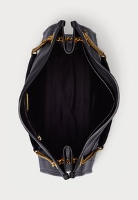 Melnas ādas rokassoma ar zelta ķēdes akcentiem. Atvērts skats atklāj tumšu audumu odere un divas iekšējās kabatas ar strukturētu, gludu formu.