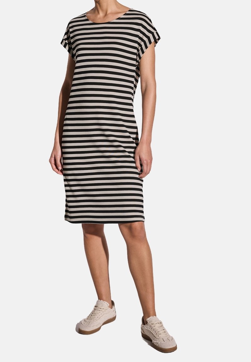 Pasiasta sukienka z krótkim rękawem w kolorze czarnym i kremowym. Luźny krój, do kolan, miękka tkanina. Nosi się z jasnobeżowymi trampkami.