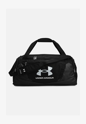 Svart duffelväska med en stor vit Under Armour-logotyp, slitstarkt tyg, dubbla handtag, justerbar axelrem och flera dragkedjefickor.