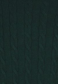 Tissu tricoté vert foncé avec un motif en torsades relevées composé de colonnes verticales tressées.