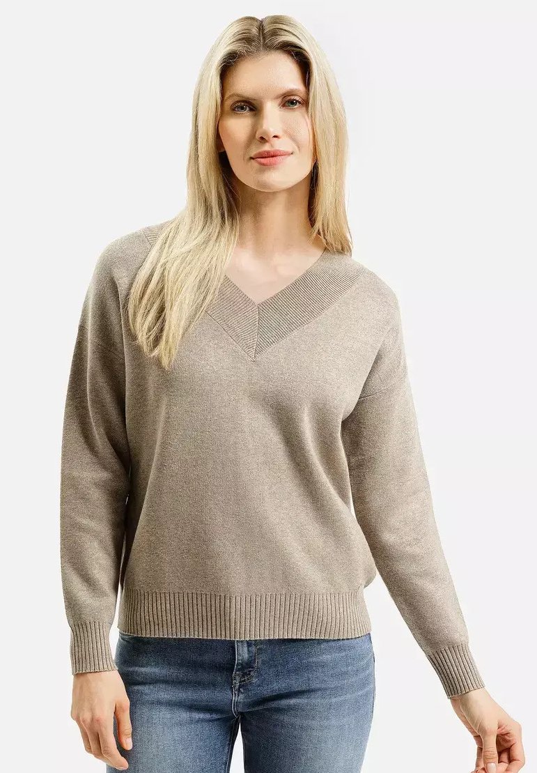 Beżowy sweter z dekoltem w serek, z długimi rękawami i prążkowanym dołem. Miękka faktura, luźny krój oraz subtelny wzór dzianiny wzdłuż dekoltu.