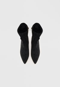 Stivaletti neri in suede con punta affusolata e design pieghettato, dotati di una cerniera laterale per la chiusura. Texture liscia senza motivi visibili.