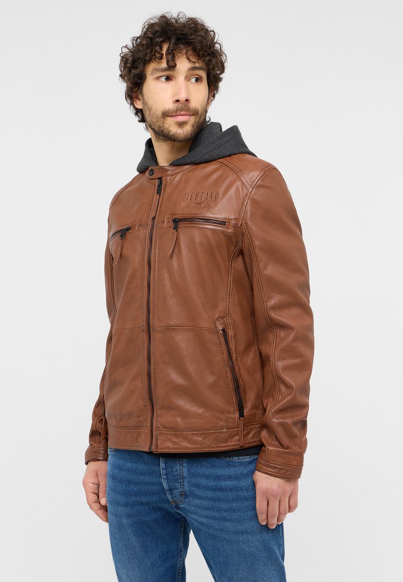 Braune Lederjacke mit Reißverschluss vorne, zwei mit Reißverschluss versehenen Brusttaschen und einer grauen Kapuze. Die glatte Textur und das taillierte Design verleihen einen modernen Look.