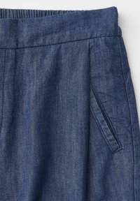 Blue denim fabric pants with an elastic waistband and a slanted side pocket.