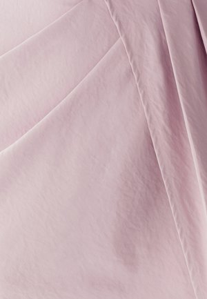 Tessuto rosa chiaro, texture liscia, con una sottile lucentezza e pieghe piegate. La cucitura visibile aggiunge dettagli alla superficie del materiale.