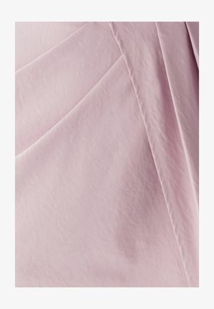 hele roosa kangas, sile tekstuur, kerge läikega ja volditud kortsudega. Nähtav õmblus lisab materjali pinnale detaili.