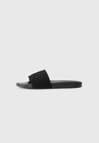 Black slide sandal featuring a textured fabric upper, flat rubber sole, and minimalistic design. No visible logos or hardware details.