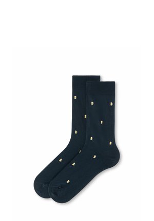 Ein Paar dunkelblaue Socken mit einem sich wiederholenden Muster kleiner Bierkrüge, verteilt auf dem Stoff vor weißem Hintergrund.