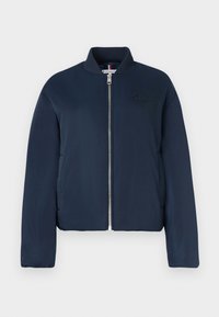 Navy bomber jacket with a zip front, ribbed collar, and subtle logo detail. Made of smooth fabric with a slightly padded texture.