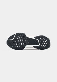 Black and white sneaker sole with textured rubber for grip, featuring a patterned design and a smooth, cushioned midsole.