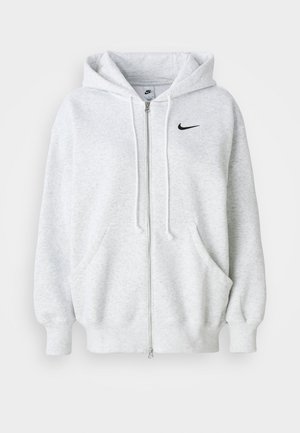 Haut de sweat à capuche zippé gris clair avec poches avant, capuche avec cordon de serrage, poignets côtelés et un petit logo Nike noir sur la poitrine.