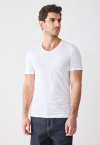 White short-sleeve t-shirt with a v-neck design, made of soft fabric. Features a fitted cut with minimal seams and no visible patterns.