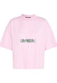 Světle růžové oversized tričko s krátkým rukávem, vysokým kulatým výstřihem a odrazovým textovým logem "KARL LAGERFELD" umístěným ve středu na přední straně.