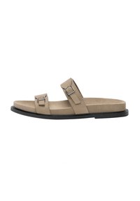 Beige suede sandals with two adjustable straps, silver rectangular buckles, low flat black rubber sole, and smooth texture.