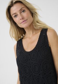 Black crochet tank top featuring a round neckline and intricate circular patterns throughout. It has a textured, open-knit design.