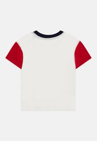 Short sleeve t-shirt in white cotton with red sleeves and a navy collar. Soft texture, classic fit, and no visible prints or patterns.