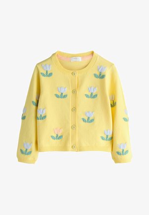 Kollane kardigan, millel on valge, roosa ja roheline tikitud tulpimuster. Sellel on ümmargune kaelus ja eest nööbitav sulgemine.