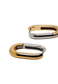 Para dwóch-tonowych złotych i srebrnych owalnych kolczyków w kształcie obręczy z gładkimi, wypolerowanymi powierzchniami na białym tle.