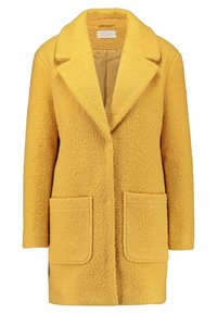 Cappotto giallo testurizzato con colletto a risvolto, due tasche frontali e un'esterno morbido e peloso. Interno foderato in una tonalità più chiara.