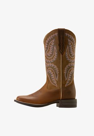 Brown leather cowboy boot with decorative stitching in blue and pink paisley pattern. Features a pointed toe and stacked heel.