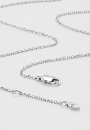 Collier en chaîne argentée avec fermoir de homard et petit pendentif en forme de goutte sur fond gris clair.