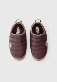 Maroon spalvos siuvinėtos šlepetės, su smėlio spalvos apdaila, minkštu kailiniu pamušalu ir apvaliu pirštu. Šone yra logotipas ir matinė pado tekstūra.