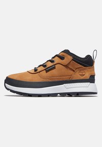 Brązowe zamszowe sneakersy z czarnymi akcentami, białą podeszwą środkową, teksturowaną gumową podeszwą oraz okrągłymi sznurowadłami. Posiadają metkę z logo z boku.