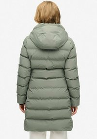 Gevoerde parka in zacht groen, knielang met een capuchon. Heeft een geborduurd oppervlak en elastische manchetten, ontworpen voor warmte en comfort.