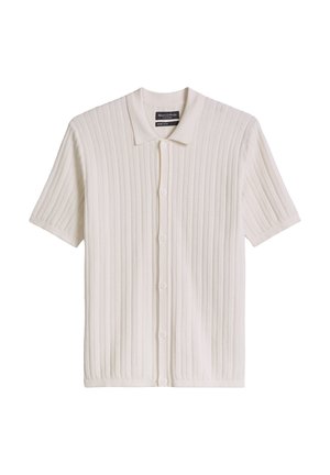 Chemise en tricot à manches courtes, boutonnée, de couleur beige clair avec une texture côtelée et un col pointu.