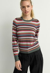 Pull en tricot doux à rayures multicolores. Col et poignets côtelés verts. Rayures en rose, rouge, violet et vert olive.