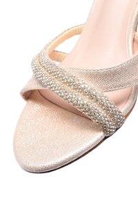 Sandalo con tacco alto beige in tessuto glitterato, con punta aperta e doppie fascette scintillanti adornate di strass sul davanti.