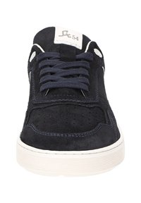 Dunkelblaues Wildleder-Sneaker mit weißer Sohle, blauen Schnürsenkeln und einem weißen Etikett an der Zunge, das mit "54" beschriftet ist, sowie einem kleinen Logo.
