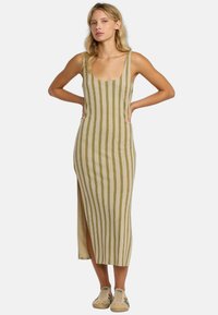 Vestido de tirantes hasta la rodilla en color beige con rayas y líneas verticales verdes, y una abertura lateral. Confeccionado en una tela texturizada, presenta un escote redondo.