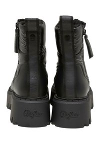 Černé kotníkové boty s polstrovanou texturou, které mají vysokou platformu a detail loga na zadní straně. Obsahují zip a štítek pro nastavení.