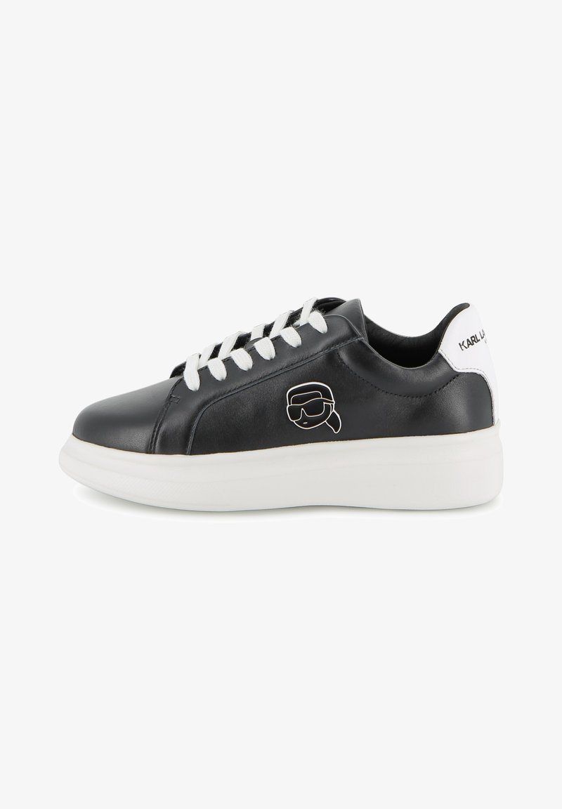 Μαύρο δερμάτινο αθλητικό παπούτσι με λευκά κορδόνια και λευκή σόλα. Διαθέτει λογότυπο καρτούν χαρακτήρα στο πλάι και κείμενο στη φτέρνα.